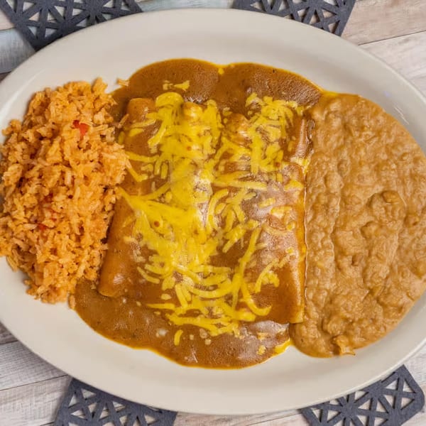 Margaritas & Fajitas Mexican Kitchen's enchiladas with rice and refried beans on a white plate.