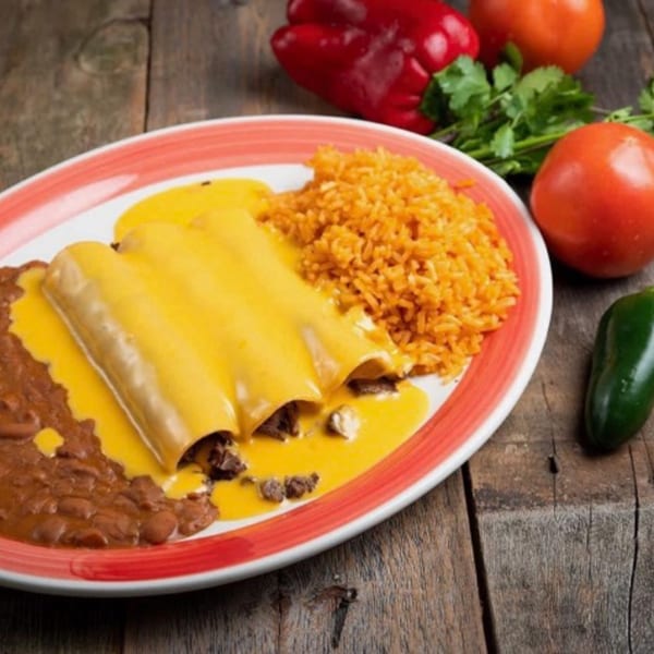 Three cheesy enchiladas with rice and refried beans on a white and red plate, with vegetables.