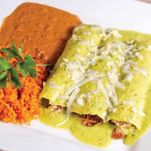Two green enchiladas topped with cheese, served with orange rice and refried beans.